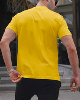 male model wearing yellow round neck tshirt with black pant and hand watch
