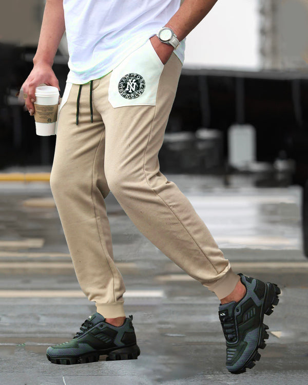 Model wearing newyork logo printed beige cargo pant with sneakers